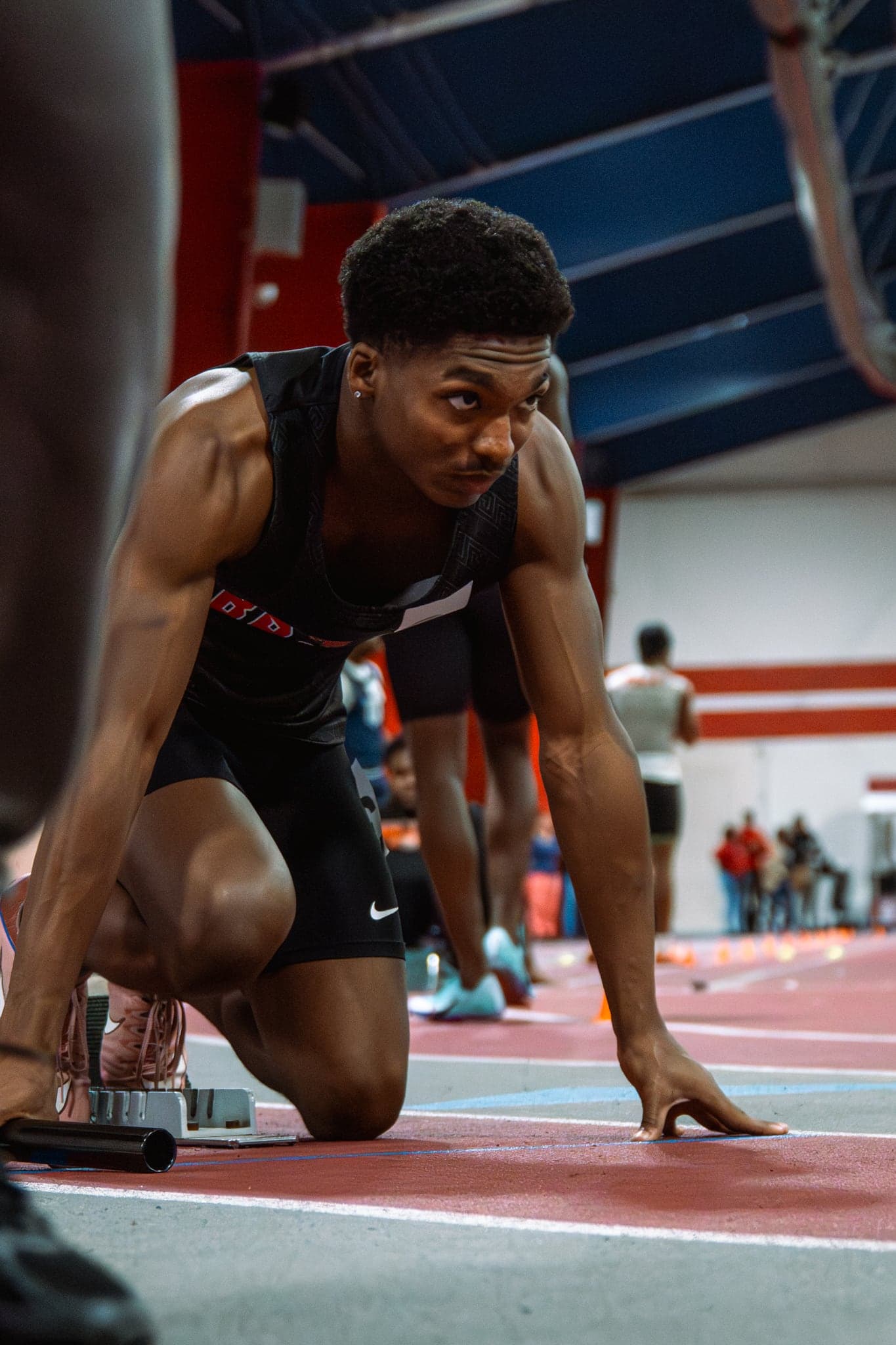 A sprinter set in the blocks moments before the gun