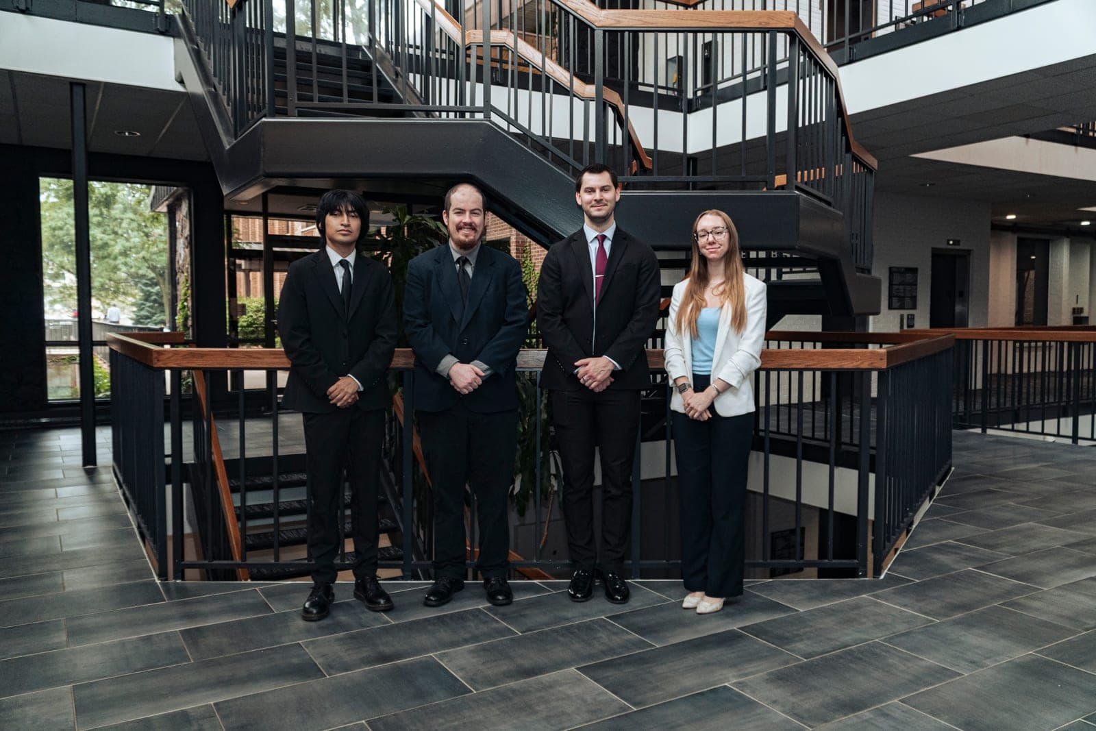 A company team photographed together on an office staircase